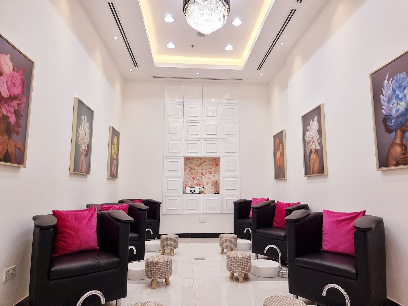 Pedicure lounge with black chairs and pink cushions